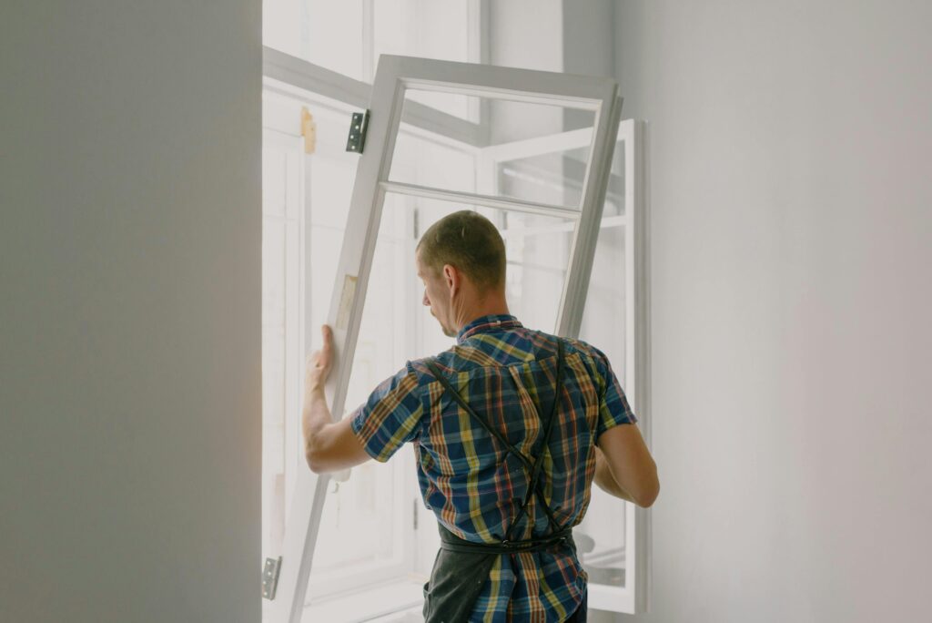 pexels-photo-5691531-5691531 A professional installer fitting a modern window in a well-lit home interior.